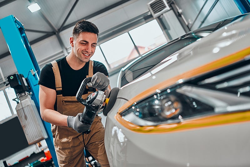 A technician detailing a car
